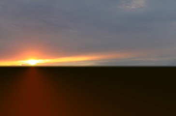 Fototapeta premium Orange sunset in summer over black earth against blue sky