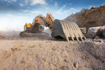 Large excavator in an excavation in summer