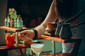 Karpaty, Ukraine, Shipot waterfall - July 20, 2019. A colorful Ukrainian man with a beard is making coffee in the sand outdoors near Shipot waterfall.