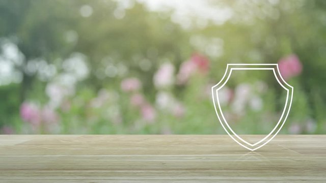 Security shield with check mark flat icon on wooden table over blur pink flower and tree in garden, Technology internet cyber security and anti virus concept