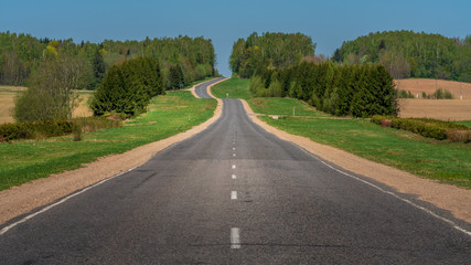 Fototapeta na wymiar Empty country road vanishing toward horizon 