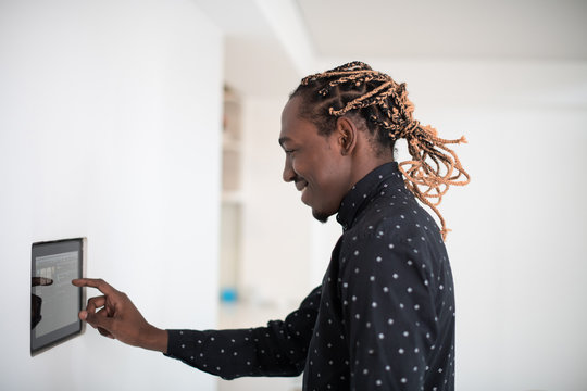 African man using smart home screen