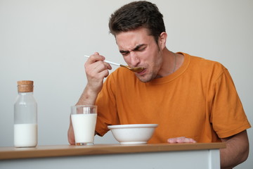The guy in a yellow T-shirt is having breakfast