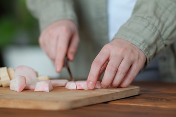 Obraz premium Girl cuts a peeled red fresh apple with a knife