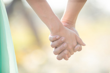 Two lovers hold hands together, selective focus