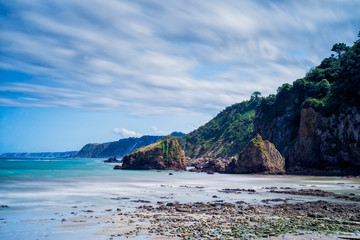 sun and clouds on a beach in Asturias next to its cliffs