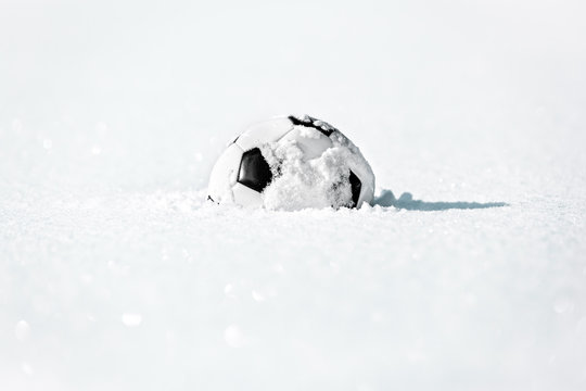 Fu&szlig;ball liegt im Schnee, Konzept Winterpause f&uuml;r Fu&szlig;baller, Textfreiraum