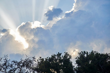 blue sky with sunbeams and clouds.