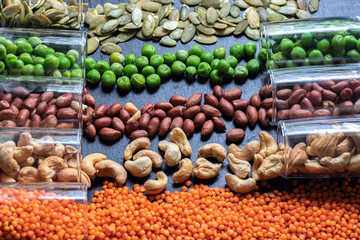 An assortment of products for vegetarian dishes.  Beans, green peas, pumpkin seeds, cashew nuts, peanuts, lentils.  Rich in protein and healthy elements.  Copy space.  Dark background.