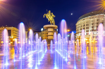 Square Macedonia in Skopje at night with dancing illuminated fountains and statue of Alexander the Great (warrior on horse) at background