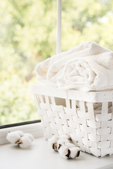 Fototapeta na wymiar White laundry basket next to a window