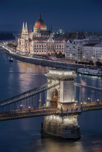 Budapest, Hungary - The world famous illuminated Szechenyi Chain Bridge with the Parliament of Hungary and sightseeing boat on River Danube taken at blue hour