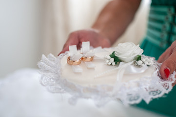 Couple of gold wedding rings on the white pad