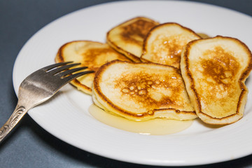  Fried pancakes in a pan with honey