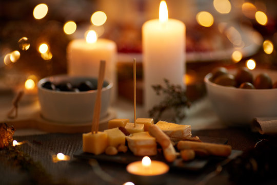Close-up of cheese appetizer on the dining table with candles ready for dinner