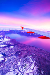 Erstaunliche Aussicht aus dem Flugzeugfenster während des Sonnenuntergangs über den Bergen in der Schweiz