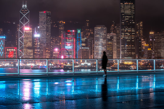 Fototapeta People stand in front of Victoria Harbor, Hong Kong at raining night