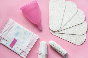 Sanitary pad, menstrual cup and tampon on pink background