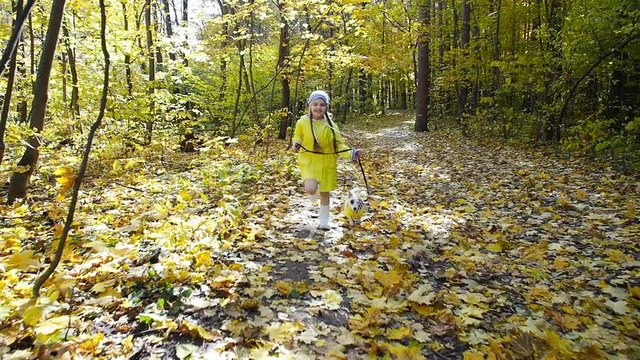 Concept of pets, family and friendship. little cute girl runs through the autumn forest with a dog