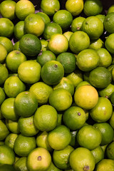 Looking down on pile of vibrant green limes in a grocery store
