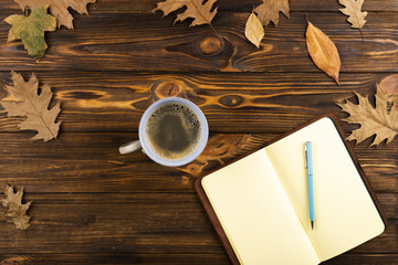 Coffee and notebook on wooden background