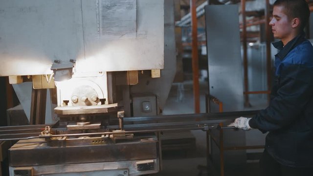 Mens working with sheet metal on CNC hydraulic press brake. Factory production