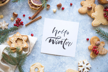 New Year and Christmas background with word Hello winter. Christmas candy cane gingerbread on black background.