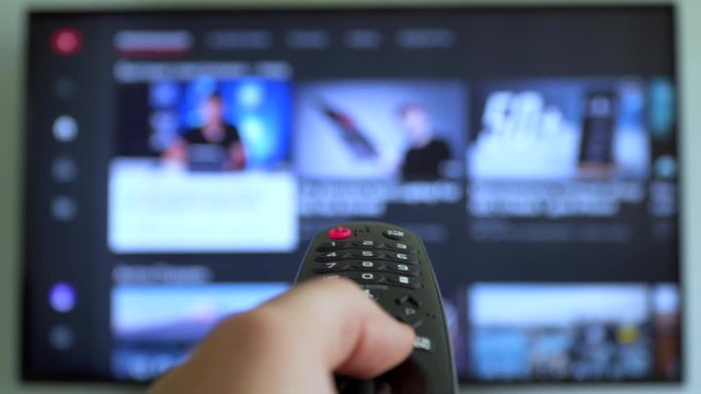 Internet online cinema smart tv Channel surfing. hand holding the TV remote control smart television