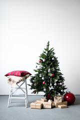 Christmas tree decorated with Christmas toys with gifts under the tree in a bright room. Merry Christmas and Happy Holidays! 