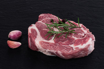 Raw meat,  steak with spices on black background