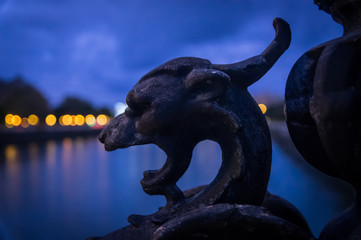 Statue of dragon on dark blue backgorund. Clear bokeh lights.