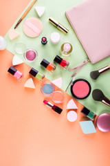 Make up accessories on orange cantaloupe and mint green background. Beauty products colorful fashion flat lay