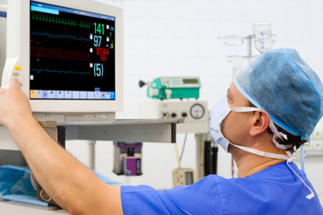 Anaesthesiologist at monitor in operation room