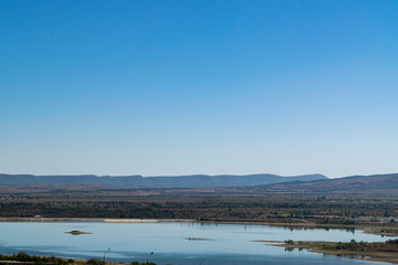 Crimean landscape. Steppe lake in the foreground and mountains covered with fog in the background.