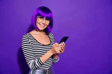 Portrait of cute person with violet fringe holding modern technology looking isolated over purple...