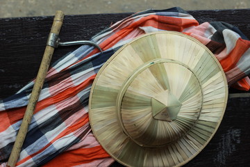 flat lay details showing the tools and colorful clothing and bamboo woven hat of a traditional Northern Thailand Thai Elephant Mahoot trainer, Southeast Asia