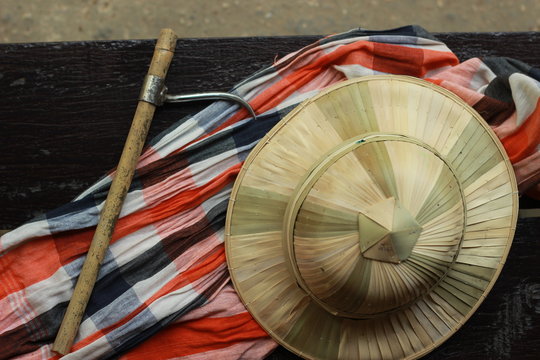 flat lay details showing the tools and colorful clothing and bamboo woven hat of a traditional Northern Thailand Thai Elephant Mahoot trainer, Southeast Asia
