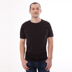 Fototapeta premium Men's Blank Black T-Shirt Apparel Mockup Bella Canvas Front. Shirt Mock Up Clothes. Young man in blank black tshirt front isolated. Mock up template for design print