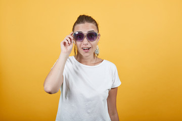 Girl wearing shades feeling delighted about it as looks good on her photograph. Can be used for sunglasses commercials also reaction is Wow shows lady is happy