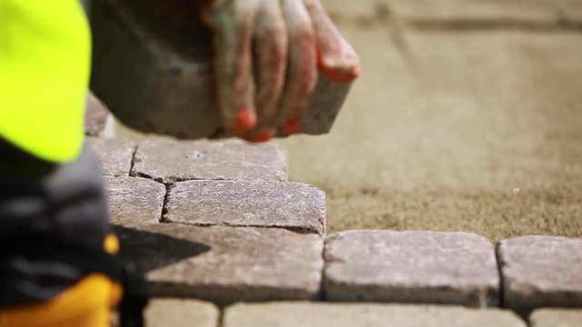 Stone Pavement Road Construction Workers Wearing Knee Protection. Fitting stone tiles