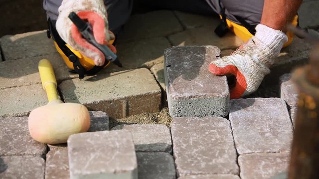 Stone Pavement Road Construction Workers. Cutting Paving Blocks For Corners