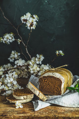 Freshly baked rye handmade breads on old wooden table with linen napkin and apricot tree blossom branch