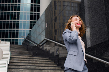 business woman talking on the phone in the background of an office building