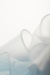 close up view of crumpled transparent disposable cups on white background
