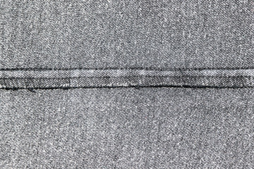 Closeup of the inner side of a black denim fabric with the black overstitch