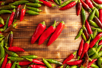 Green and red chili peppers on a wooden board