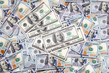 One hundred dollar bills on the table as background