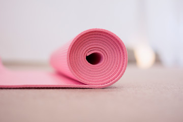 Pink yoga mat, rolled up.