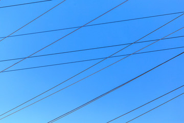 Electric wires against the blue sky