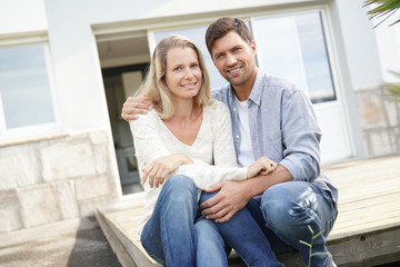 Obraz premium Cheerful couple in front of new house